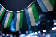 A Garland Of Sierra Leone National Flags On An Abstract Blurred Background