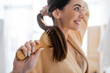 © LIGHTFIELD STUDIOS - smiling and blurred young woman brushing shiny hair in bathroom.