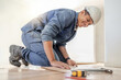 © Lumeez/peopleimages.com - Handyman, wood flooring installation and happy at workplace, industry and home development vision. Black man, construction worker and floor with smile, helmet and tools for diy, interior and design
