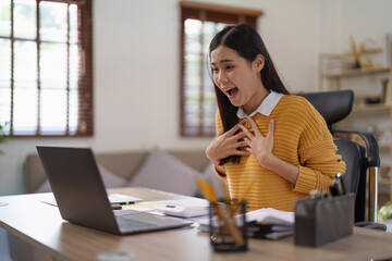 Young happy woman using laptop and celebrating victory and success, have good news, job celebrating achievement.