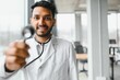 © Serhii - Handsome Indian Male Doctor holding empty white or blank dropper bottle