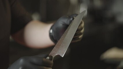 Close-up of a chef checking the sharpness of a knife with his hands. High quality 4k footage