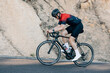 © Artem Varnitsin - Male cyclist riding up on a road. Professional cyclist in sportswear doing intense training outdoors.