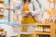 Woman with metal basket buying personal hygiene items in zero waste shop. Female choosing eco-friendly vegan cosmetics products in sustainable plastic free store.