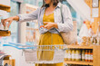 © nataliaderiabina - Woman with metal basket buying personal hygiene items in zero waste shop. Female choosing eco-friendly vegan cosmetics products in sustainable plastic free store.
