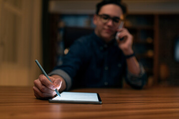 Wall Mural - Young man wearing glasses graphic designer working late at night