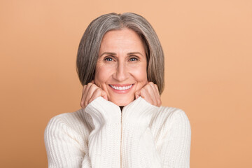 Sticker - Photo of cheerful toothy beaming smile cute old grandmother touch cheeks look you wear stylish white knit sweater isolated on beige color background