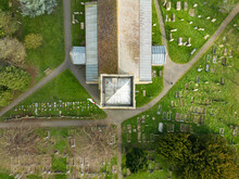 Drone Top Down View Of A Typical Old English Church With Its Fine Leaded Roof. Surrounded By Grave Stones.