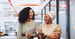 © Siphosethu F/peopleimages.com - Black women, laughing or walking with business technology, paper or documents in modern office, coworking space or marketing company. Smile, happy or comic creative designers bonding in slow motion