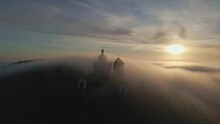 Svaty Kopecek in Mikulov shrouded in thick fog. Aerial video of South Moravia