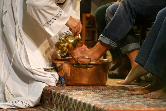 maundy thursday celebration in a parisian catholic church. priest washing faithfuls' feet.