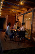 © Caia Image - Happy couples hugging, enjoying dinner at patio table