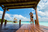 Fototapeta Londyn - Couple relaxing on a pier Bacalar lagoon Mexico
