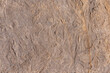 Stone textured wall is sand colored with orange patterns and various bulges. Stone background is sand-colored.