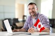© BillionPhotos.com - Young business man at work with flag of Canada .