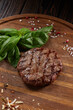 Grilled steak on wooden chopping board with spinach and spices