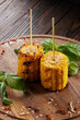 Grilled corn cobs with salt spices and herbs on wooden board. Closeup