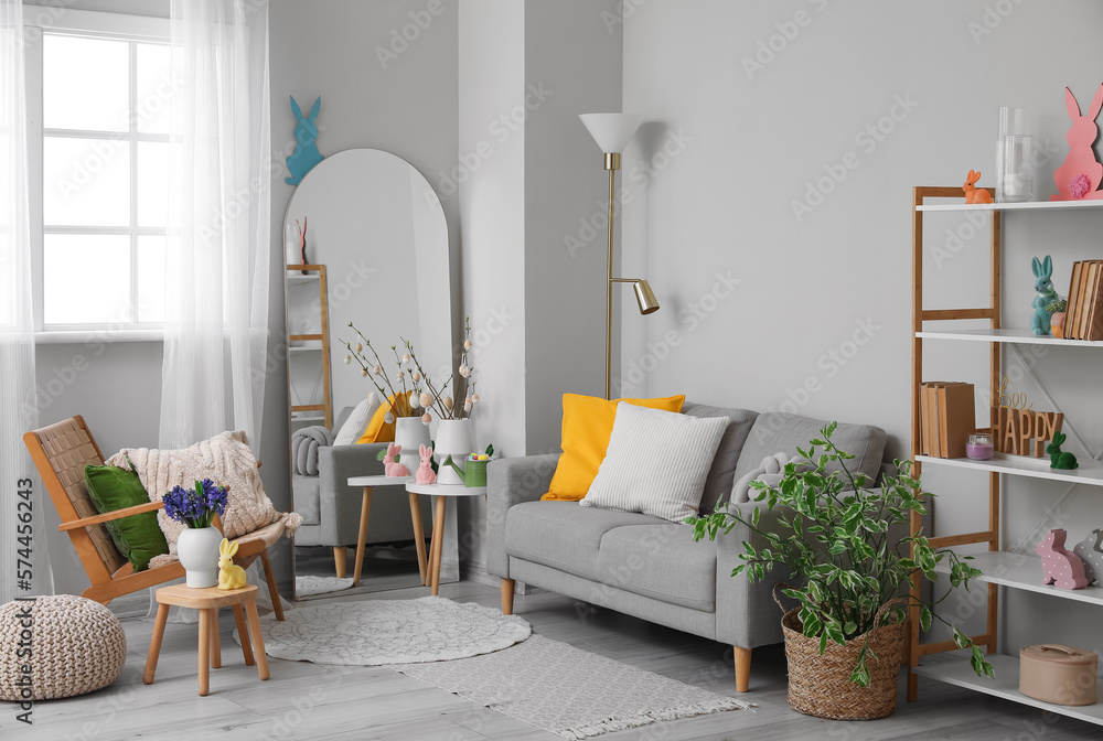 Interior of living room with Easter decor, sofa and mirror