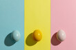 Image of yellow, pink and blue easter eggs and copy space on yellow, pink and blue background