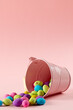 Image of multi coloured easter eggs and pink bucket with copy space on pink background
