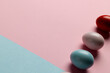 Image of multi coloured easter eggs with copy space on pink to blue background