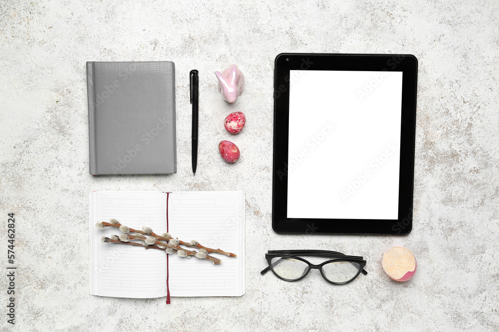 Office stationery with tablet computer and Easter decor on grunge background