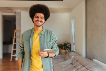 Portrait of mixed race man using tablet at home.