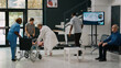 © DC Studio - Father carrying unconscious kid in facility lobby to receive help from specialist, worried parents waiting to do emergency consultation with physician. Medic consulting sick girl in lobby.