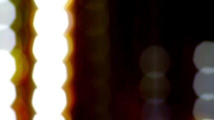 Wall Mural - Glowing dotted bokeh lines running down across a black background. 4K Loop. Abstract straight line dot run on the screen. Laser light dots stripe light technology background. Blur Light Circles.