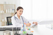 © jokekung - asian female doctor reading and order treatment process on patient chart, she sitting and smile in hospital