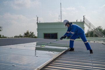 Wall Mural - Man using a mop and water to clean the solar panels that are dirty with dust and birds' droppings to improve the efficiency of solar energy storage