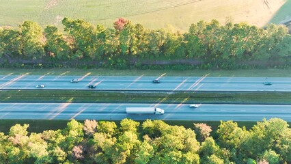 Wall Mural - Aerial view of busy american freeway with fast moving cars and trucks. Interstate hauling of goods concept