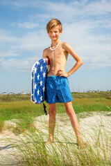 Wall Mural - Young Preteen Boy Standing on Shoreline with Boogie Board