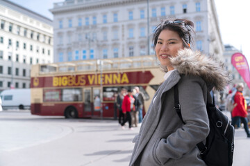 Vienna travel asian female woman smile relax on street in Vienna Austria with background of city bus tour with happiness carefree feeling,asia girl enjoy tour in Vienna Austria