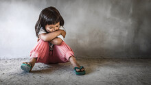Homeless Sad Little Child Girl Sitting Alone On Floor Concrete Wall Background