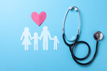  Family insurance and medical care concept. Flat lay with heart shape, stethoscope and family figure. 