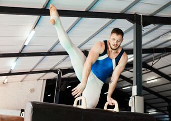 Canvas Print - Sports, gymnastics and man training on a beam for balance, flexibility and strength in the gym. Fitness, athlete and male gymnast practicing a routine for a competition or performance in an arena.