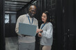 © Kirsten D/peopleimages.com - Business, black man and woman with laptop, servers and cyber security for connection, data analytics and conversation. IT specialist, female programmer and employees with device and cloud computing
