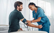 Nurse, doctor and man with blood pressure test in hospital for heart health or wellness. Healthcare, hypertension consultation and medical physician with patient for examination with sphygmomanometer