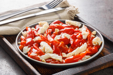 Wall Mural - Esgarraet Red pepper and cod salad is a typical Valencian dish closeup on the plate on the wooden board. Horizontal