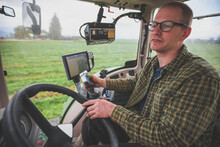 Farmer Cutting Crops With GPS Controlled Tractor, Chilliwack, British Columbia, Canada