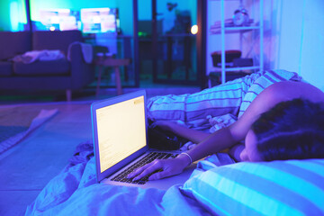 Fototapete - Night, woman and laptop while sleeping in home bed with light from website screen in bedroom. Tired student person hand with burnout asleep while online for remote work or mockup social media chat