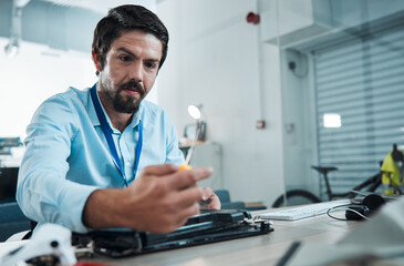 Laptop, repair and screwdriver with an engineer or handyman fixing hardware in an IT office. Computer, information technology and maintenance with a male service professional at work on technology