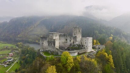 Wall Mural - Slovak castles: an aerial view of Strečno Castle, towering on a cliff above the valley with the river Váh. Autumn, stone guard castle above the hilly landscape. Traveling Slovakia.