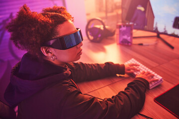 Fototapete - Hacker, cyber security and programming with black woman typing for coding, software and phishing. Neon, night and network with girl programmer at desk for ransomware, technology and developer