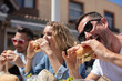 three friends eating burgers and smiling