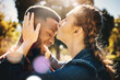 © Allistair F/peopleimages.com - Interracial couple, forehead kiss and smile in nature for love, bonding and embracing relationship. Happy woman kissing man on head smiling for loving care, affection or embrace in a park outdoors