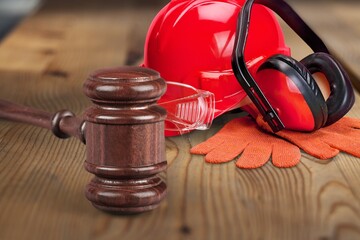 Poster - Judge's wooden hammer and worker helmet on the desk