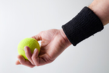 Wall Mural - Hand catching tennis ball on light isolated background