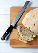 Homemade bread seen from above, with knife and light wooden background.
